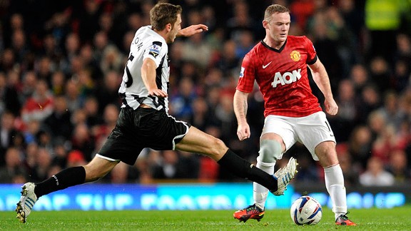 Manchester United's Wayne Rooney, right, is tackled by Newcastle's United's Dan Gosling