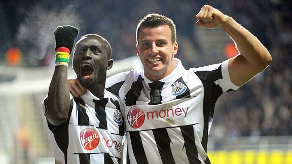 Papiss Cisse celebrates with Steven Taylor after heading home Newcastle's 90th minute winner against Anzhi