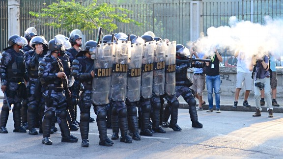 Riot police clash with protesters outside of Maracana stadium.