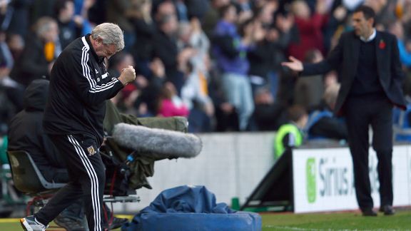 Hull manager Steve Bruce celebrates while Sunderland boss Gus Poyet looks on.