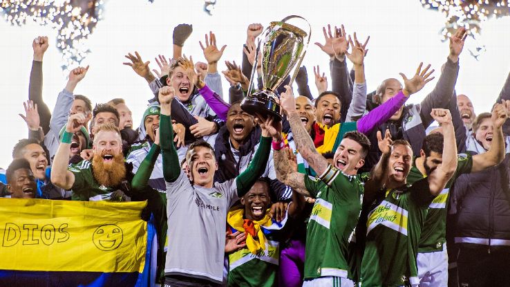 Timbers players hoist the MLS Cup trophy as they celebrate their victory.
