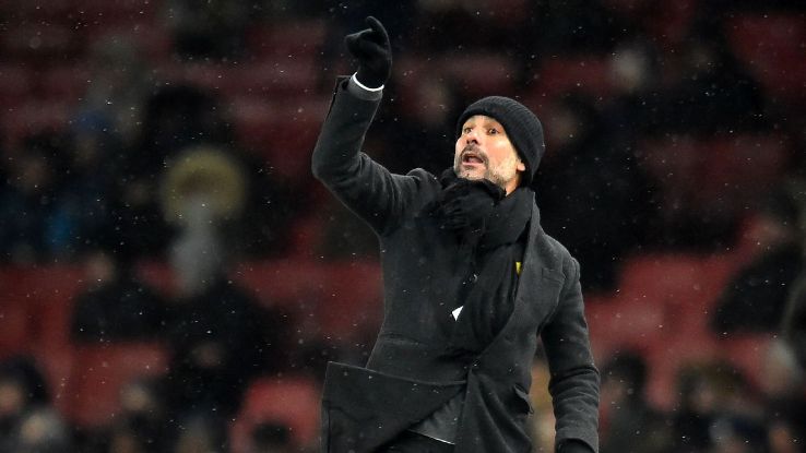 Pep Guardiola gestures on the touchline as the snow falls 