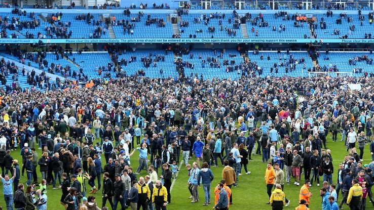 Manchester City fans invade the pitch following the Premier League win over Swansea.