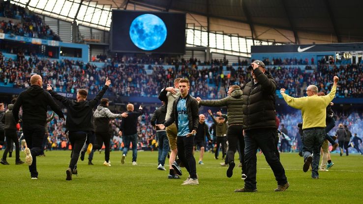 Manchester City fans invade the pitch following the 5-0 Premier League win against Swansea.