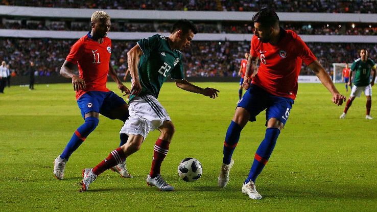 Hirving Lozano of Mexico holds off Chile's Junior Fernandez and Guillermo Maripan.