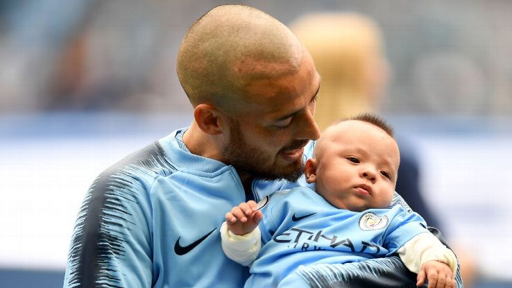 David Silva hold his son Mateo as the teams line up prior to the Premier League match between Manchester City and Huddersfield Town.