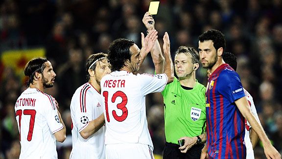 Alessandro Nesta gets a yellow card after tugging back Sergio Busquets for Barcelona's second penalty.