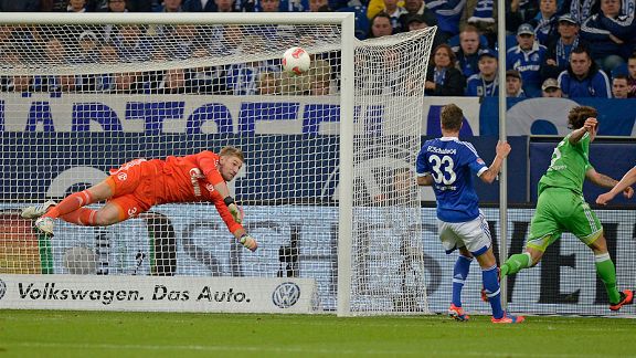 Schalke goalkeeper Lars Unnerstall saves a shot from Wolfsburg's Emanuel Pogatetz