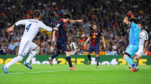 Lionel Messi of Barcelona scores his team's first goal past Iker Casillas