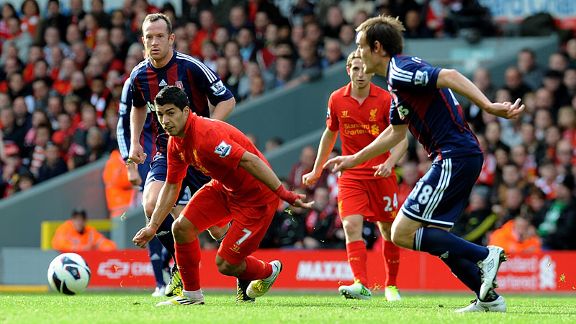 Luis Suarez of Liverpool bursts through the Stoke players