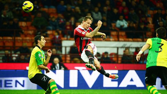 Milan's Philippe Mexes acrobatically clears his lines against Chievo