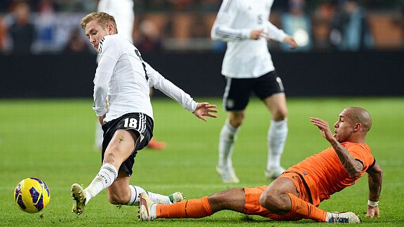 Lewis Holtby is tackled by Nigel de Jong in Germany's friendly with Netherlands