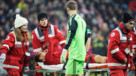 Manuel Neuer checks on Holger Badstuber as he is carried off injured against Dortmund