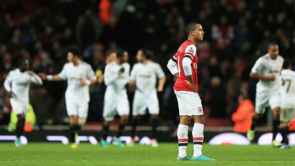 Theo Walcott is a lonely figure as Swansea celebrate one of Michu's two goals