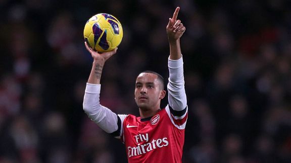 Theo Walcott celebrates with the match ball after his hat-trick helped Arsenal to a 7-3 victory