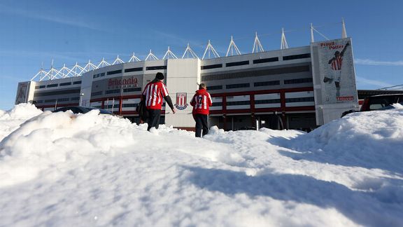 Stoke City fans make their way to the Britannia Stadium in the snow