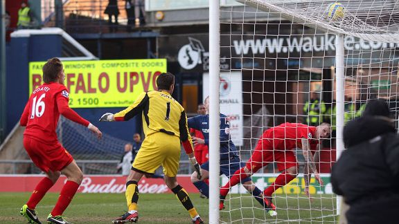 Liverpool goalkeeper Brad Jones watches on as Martin Skrtel is unable to divert Oldham striker Matt Smith's effort clear