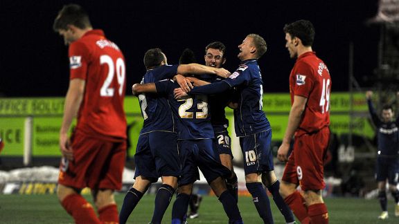 Reece Wabara is mobbed by his team-mates after making it 3-1 to Oldham