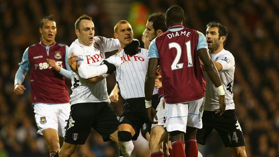 Steve Sidwell is held back by his Fulham team-mates as he squares up to West Ham's Mohamed Diame