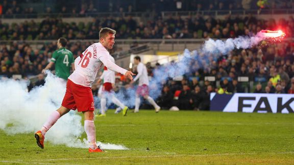 Jakub Blaszczykowski clears a flare from the field during Poland's 2-0 defeat to Ireland