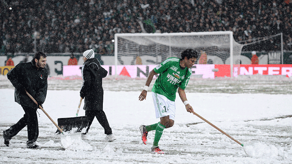 Brandao clears snow of the St Etienne pitch to make sure their game against Montpellier is completed