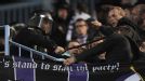 A riot policeman uses his baton on an Anderlecht fan during the Belgian side's 2-2 draw at Malaga