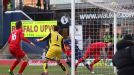 Liverpool goalkeeper Brad Jones watches on as Martin Skrtel is unable to divert Oldham striker Matt Smith's effort clear