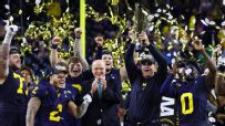 Jim Harbaugh lifts the trophy as Michigan celebrates title