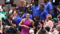 Sabalenka high-fives fans while walking to her box to celebrate