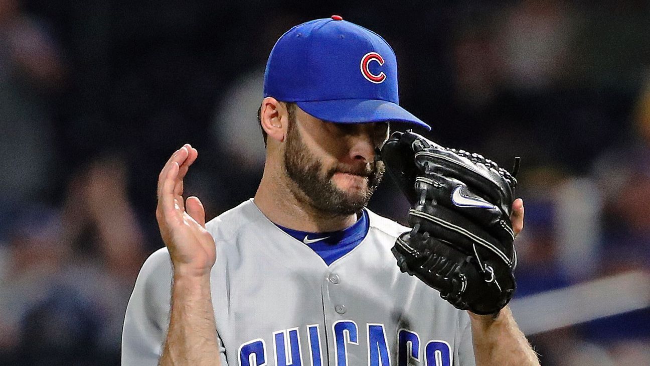 Brandon Morrow de los Chicago Cubs sufre espasmos en la espalda mientras se quita los pantalones.