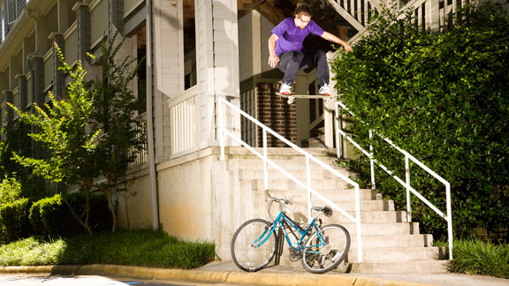 Brock frontside 180s the hard way over the stairs, the rail and the bike.