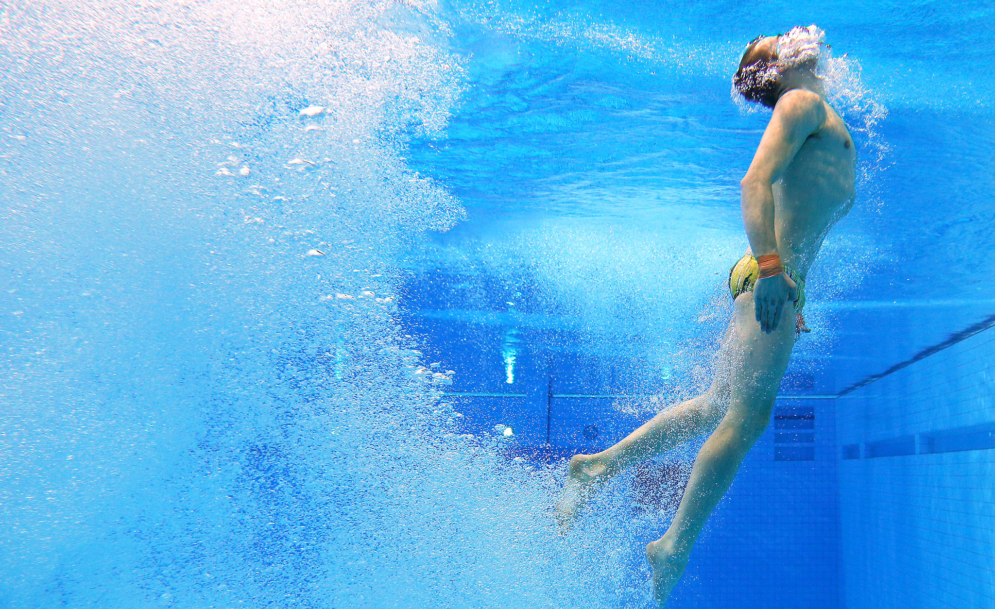 Человек под водой в бассейне