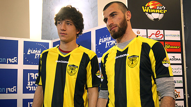 Chechen football players Dzhabrail Kadaev (L) and Zaur Sadaev, signed from Russian League club Terek Grozny, show off their new shirts during their introduction by the Beitar Jerusalem football club to the press in Jerusalem on January 30, 2013. Beitar Je