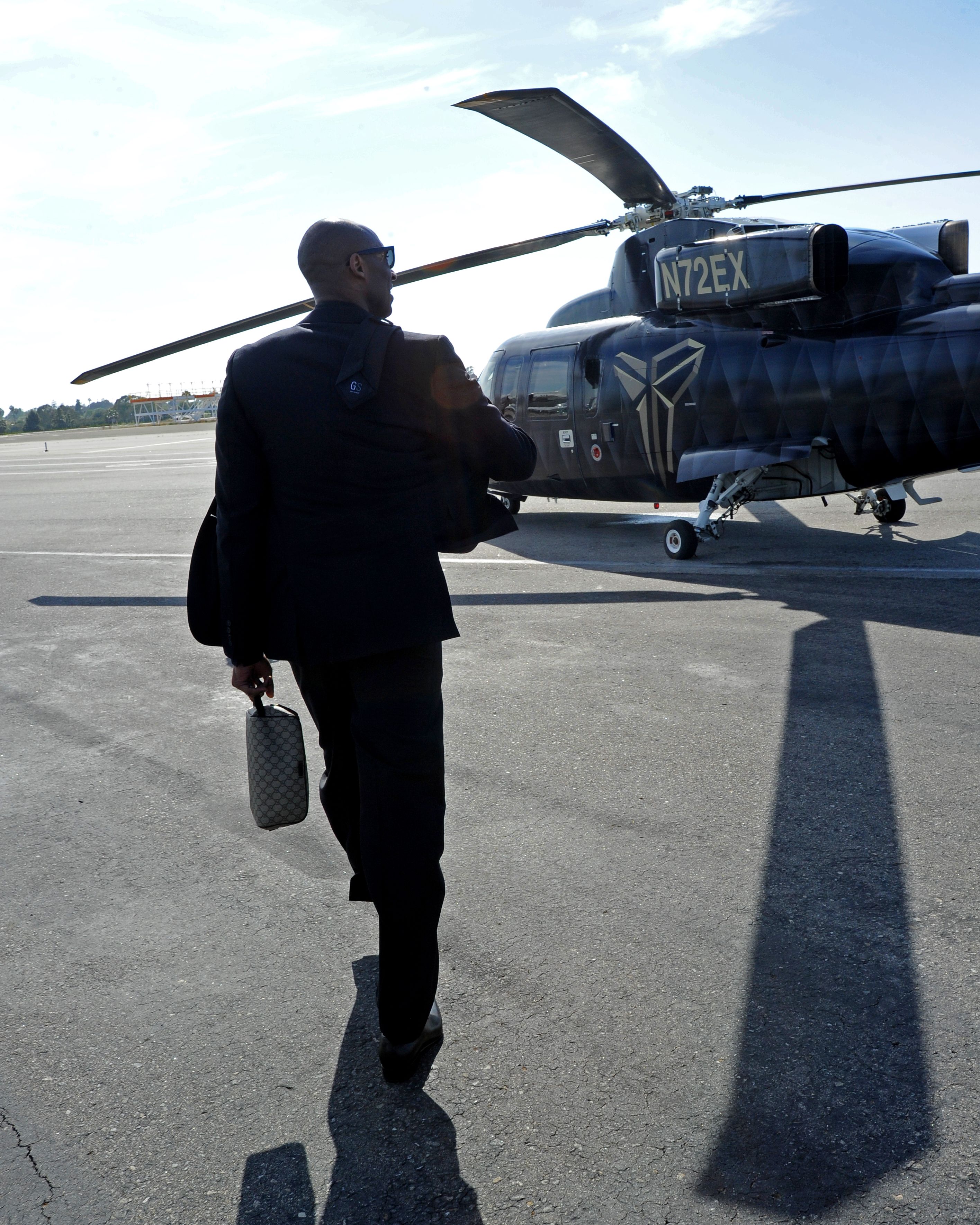 Kobe Bryant walks to his custom decorated helicopter en route to his last game ...