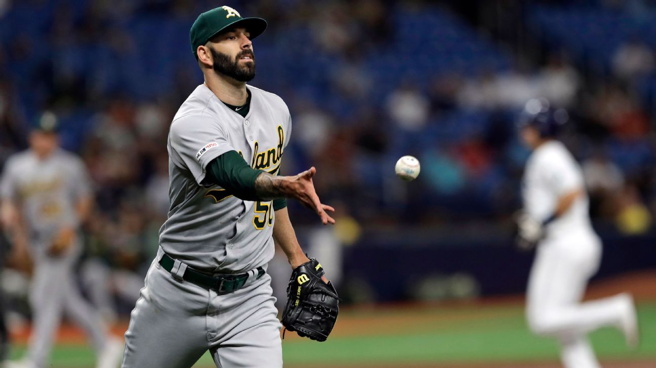 Athletics starting pitcher Mike Fiers flips the ball to first in time to get Tampa Bay's Guillermo Heredia after a grounder.