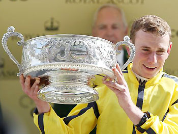 Jockey Ryan Moore celebrates with the trophy after a victory in the Coronation Stakes aboard Rizeena at the 2014 Royal Ascot meet.