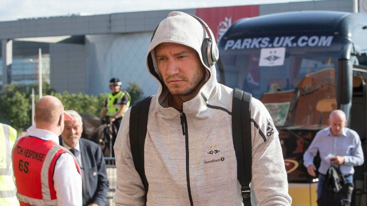 Rosenborg's Nicklas Bendtner leaves the team bus before a Champions League qualifier.