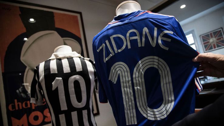 A man displays a French national football team jersey worn by Zinedine Zidane