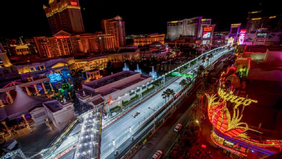 Formula 1 cars racing on the Las Vegas Strip at night
