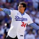Former Los Angeles Dodgers pitcher Fernando Valenzuela greets Mike Scioscia,  standing, during his jersey retirement ceremony before the baseball game  between the Dodgers and the Colorado Rockies, Friday, Aug. 11, 2023, in