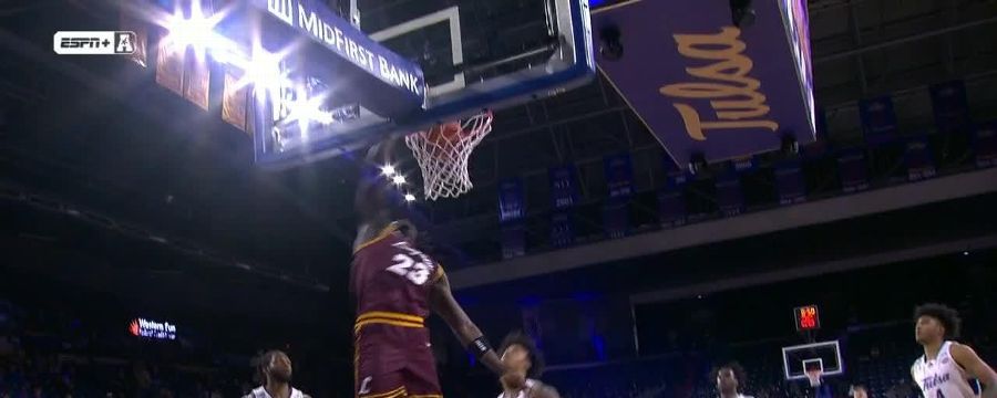Loyola Chicago's Philip Alston goes behind the back before slamming it home