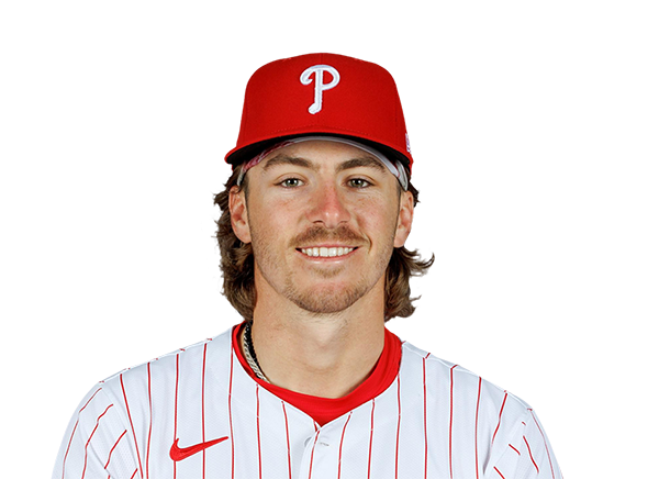 Philadelphia Phillies - Photo of Bryson Stott smiling. He is wearing his  hat sideways and has on sunglasses. He is also wearing a red long sleeve  Phillies shirt, white baseball pants and
