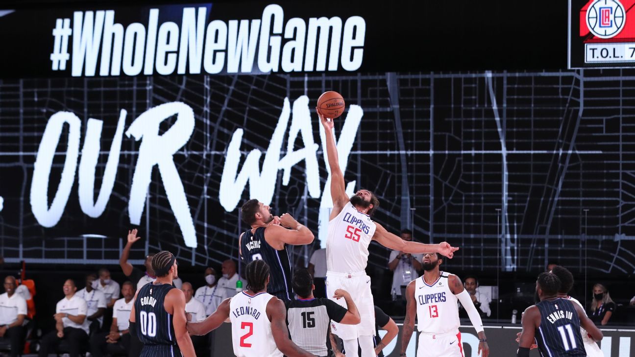 The Milwaukee Bucks' Giannis Antetokounmpo (34) falls beneath the Orlando  Magic's James Ennis III (11) and Nikola Vucevic (9) during Game 2 of the  Eastern Conference First Round playoff series at Disney's