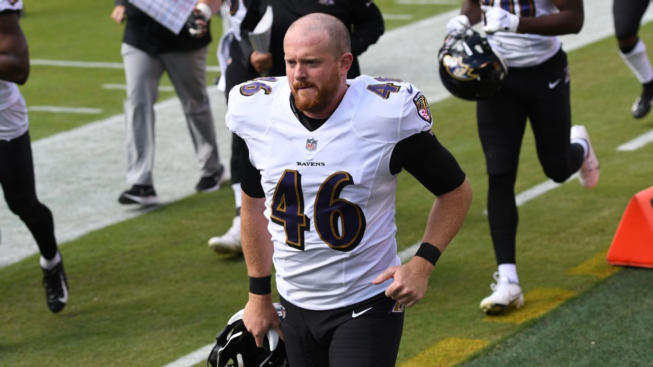 Baltimore Ravens long snapper Morgan Cox (46) waits to take the field while  holding a flag as part of the team's Salute to Service prior to an NFL  football game against the