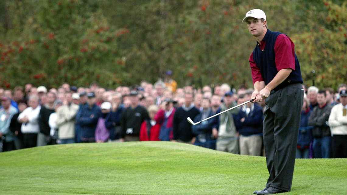 David Toms luciendo una camisa roja y un chaleco azul en 2002.