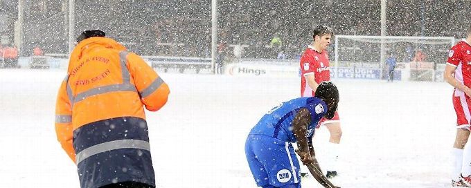 Peterborough players help shovel snow to stop match being abandoned