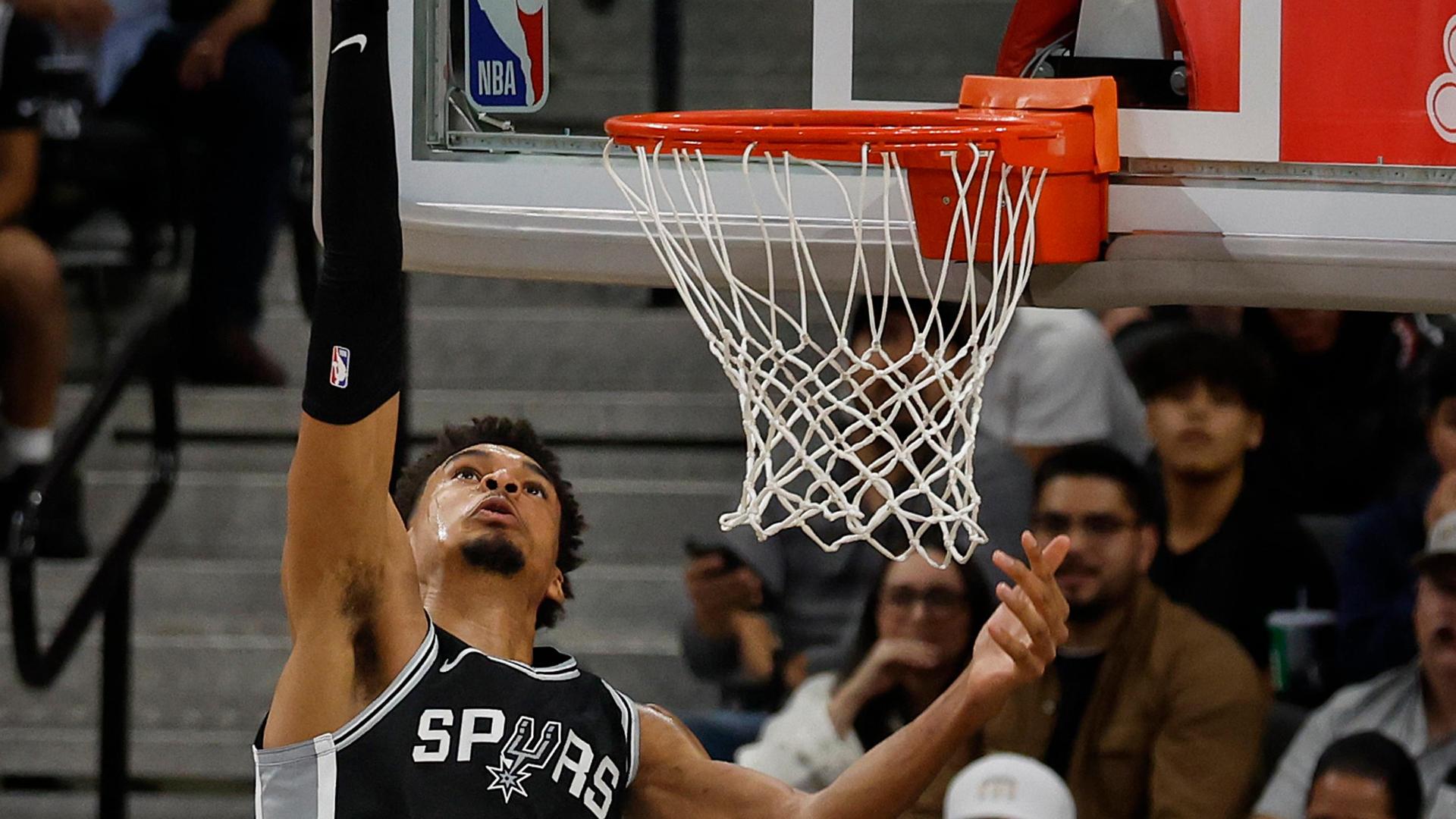 Victor Wembanyama reaches a foot over the basket on an absurd double block for the Spurs.