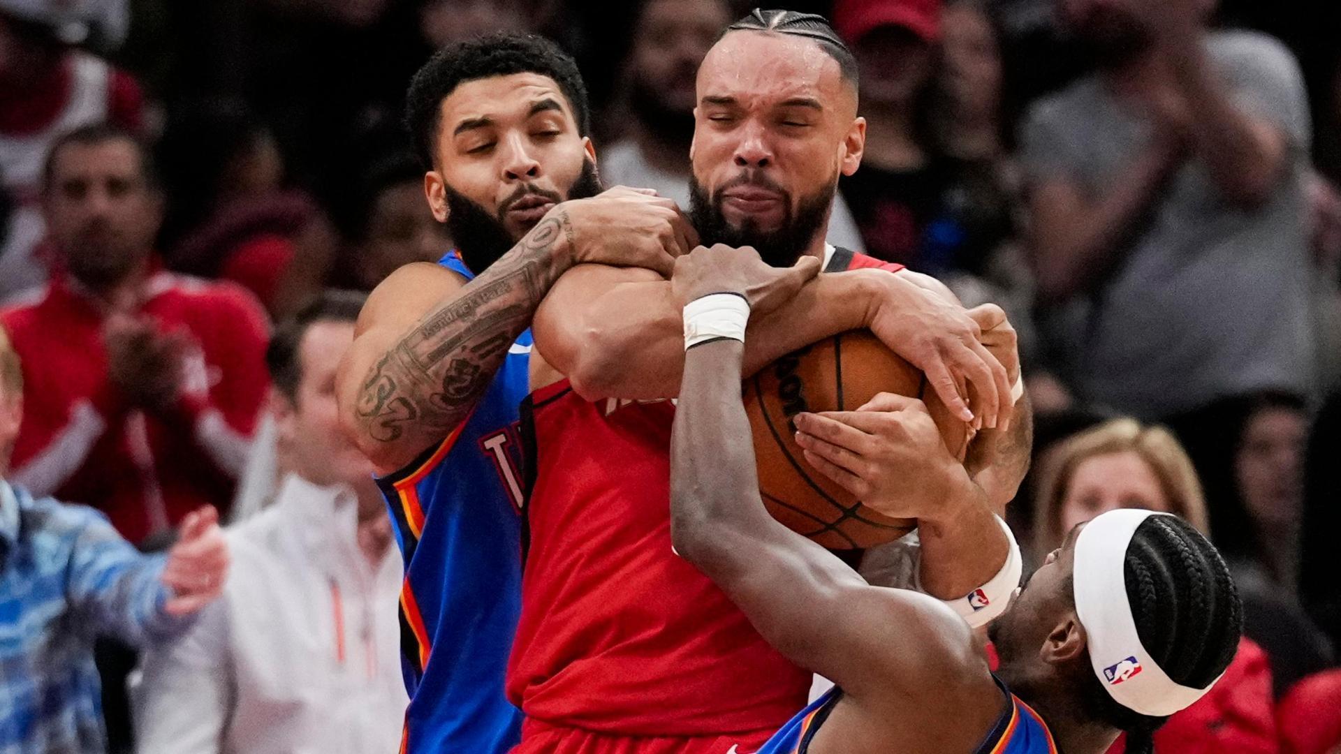 Dillon Brooks gets tangled with Shai Gilgeous-Alexander and Kenrich Williams while fighting for the ball, leading to pushing and shoving into the Rockets bench.