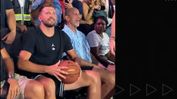 Lakers star Luka Doncic somehow connects on a long shot while sitting in a chair at Dyckman Park in New York City.