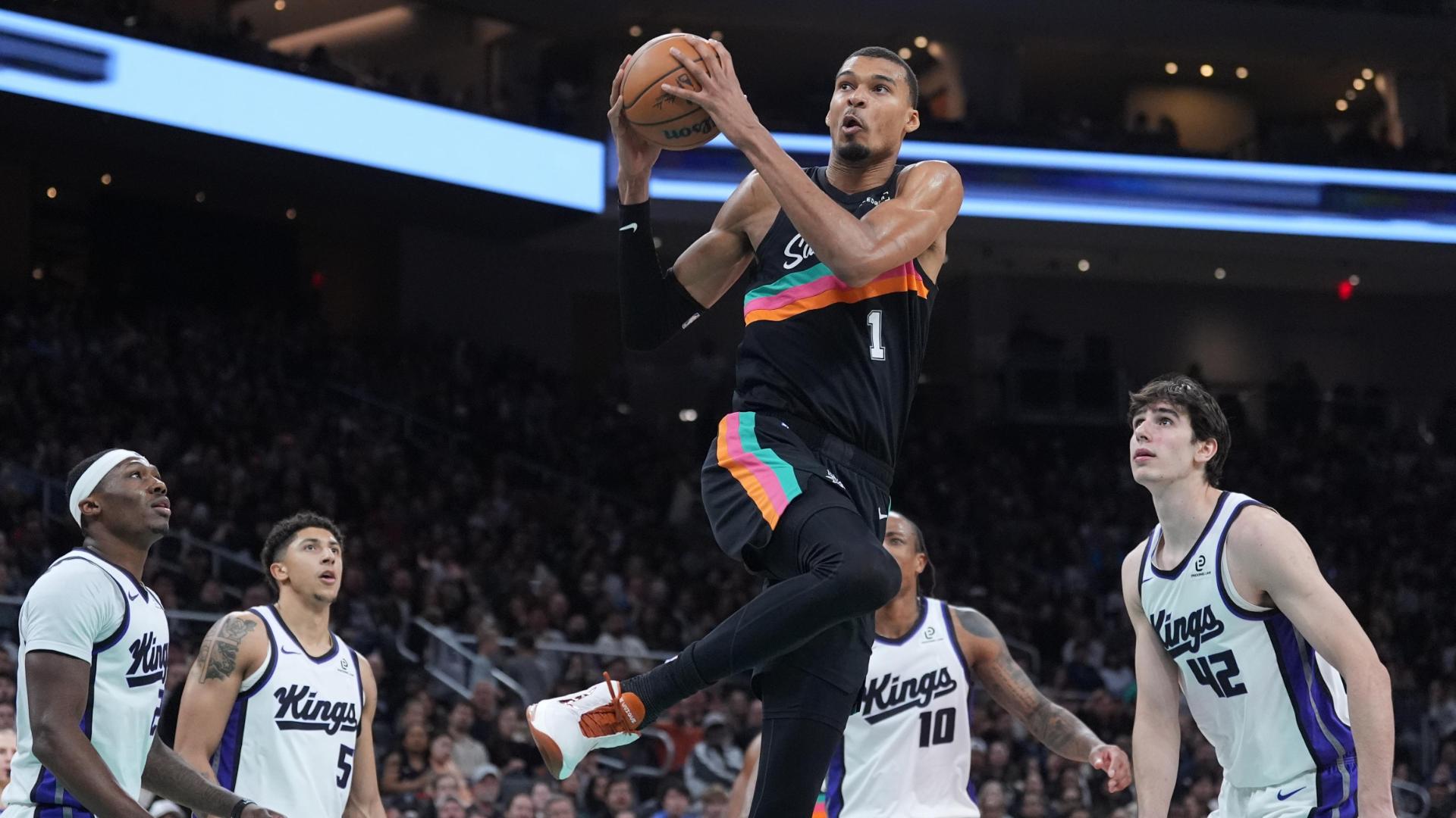 Victor Wembanyama drives to the basket and shows off some moves with a windmill dunk.